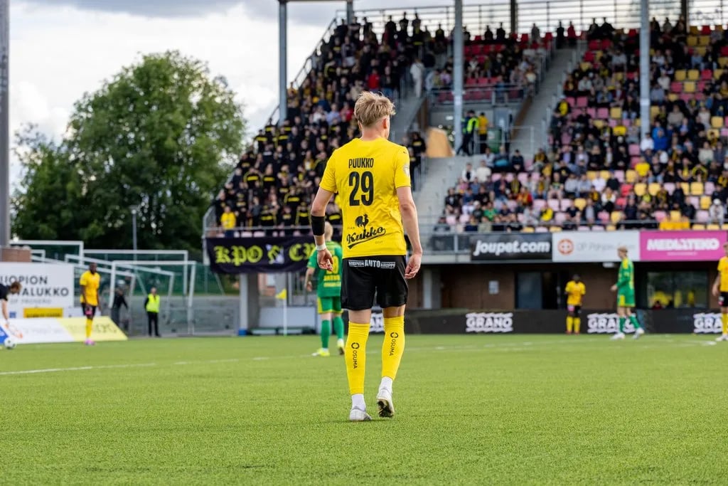 Kuvassa jalkapallokentällä peliasuinen mies selin, paidassa on numero 29 ja teksti Puukko
